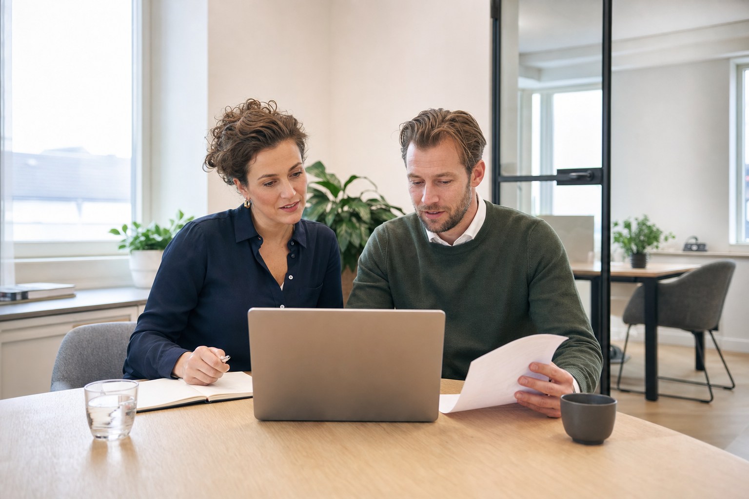 Twee medewerkers van een Nederlands administratiekantoor werken samen aan een klantvraag